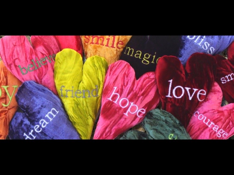 Crushed velvet heart pillows embroidered with words including hope, love, joy and courage